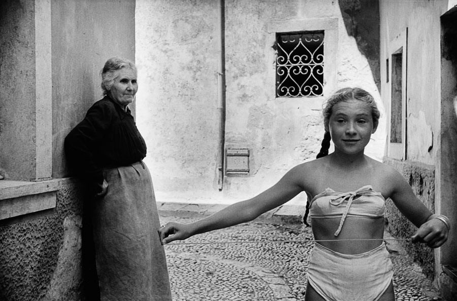 Yougoslavie, 1953. Jeune fille portant un « bikini » dans les ruelles de Dubrovnik, sous l’œil désapprobateur de sa grand-mère.