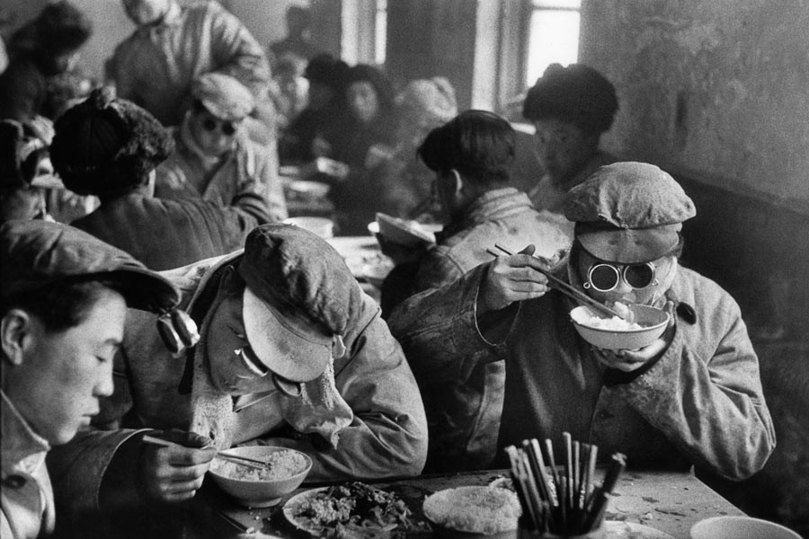 Chine, 1957. Une ingénieur dans la cantine d'une aciérie d'Anshan. Ses lunettes de protection sont attachées au bord de sa casquette.