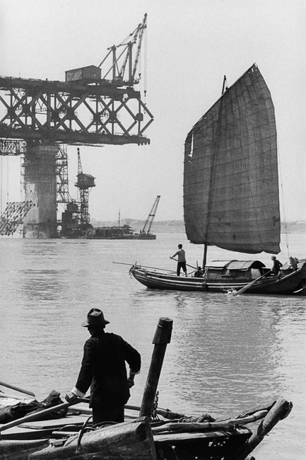Junk in front of the construction site of a bridge over Yang-tseu-kiang, Wuhan, 1957