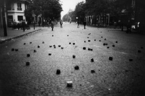 On the desert boulevard, the scattered cobblestones symbolise the end of the riots.