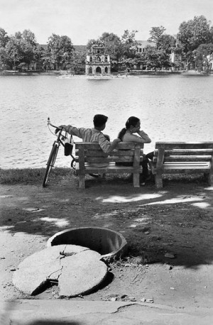 Couple along the lake in Hanoi, a shelter in the foreground, 1969