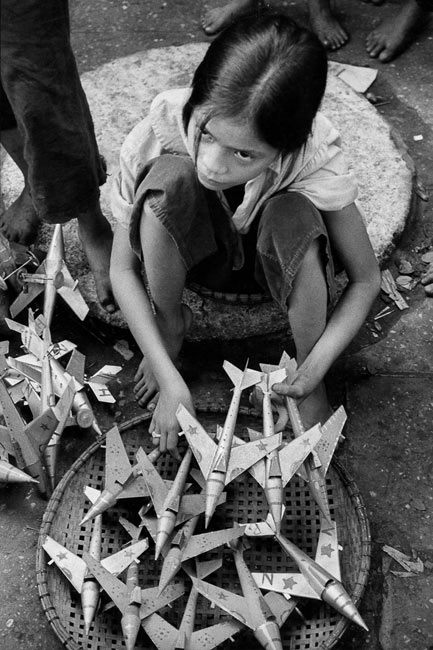 Fillette vendant des avions miniatures, répliques de MIG utilisés par l'armée du Nord, Hanoi, 1969